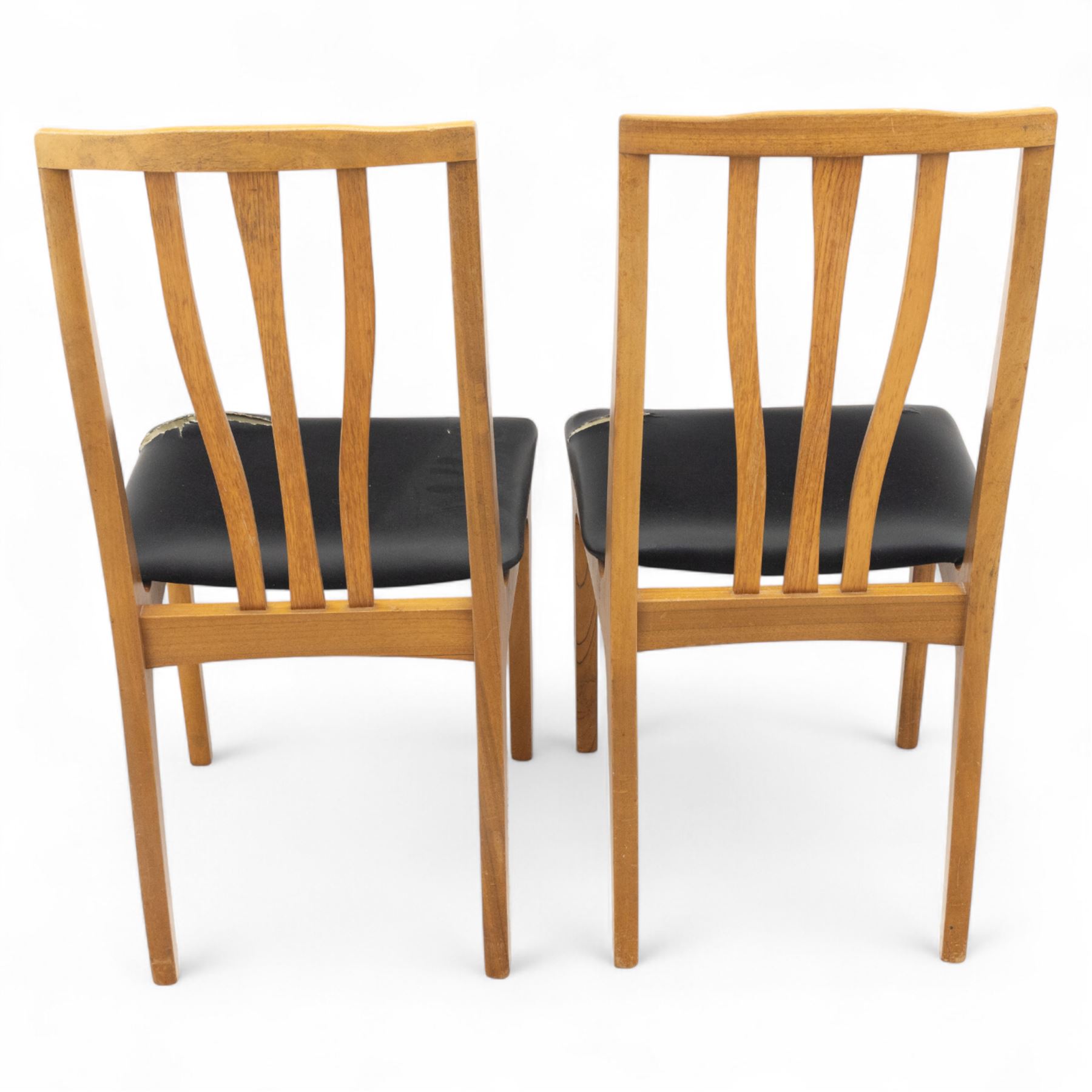 Sutcliffe of Todmorden - mid 20th century ‘S-Form’ teak dining table and chairs, the circular storable extending table with plain veneered top on tapered supports, together with matching dining chairs upholstered in black vinyl, with curved slat backs and shaped front supports, reflecting the sleek organic styling characteristic of 1960s British modern furniture design (Chairs H 93cm, W 46cm, D 46cm) (Extended 168cm)