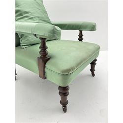 Victorian walnut open armchair, turned supports with brass and ceramic castors, upholstered in green fabric