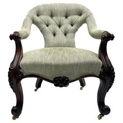 Victorian mahogany framed open armchair, upholstered in buttoned green lozenge pattern fabric, scrolled arm terminals on shaped supports carved with flower heads and foliage, shaped middle rail carved with foliate motif, on brass and ceramic castors