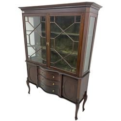 Late 19th century mahogany display cabinet on stand, projecting dentil cornice, fitted with two astragal glazed doors, base with three central serpentine fronted drawers, flanked by oval panelled cupboard, on cabriole supports