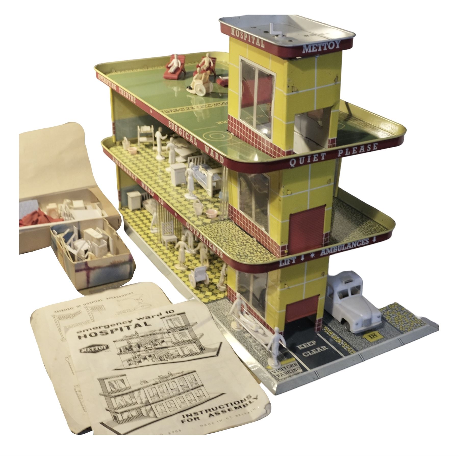 Late 1950s/early 1960s Mettoy tin-plate Emergency Ward 10 hospital set from the TV series, including over twenty figures, over sixty pieces of hospital equipment, beds, chairs, lockers, theatre fittings, stretchers etc; building is complete with movable transparent partitions, operating lift with sliding lift shaft doors and opening windows; wards with fitted swing doors; tin-plate walls with lithographed detail in yellow with red and white tiled effect, cobbled base with ambulance casualties area and lift access; boxed with instructions
