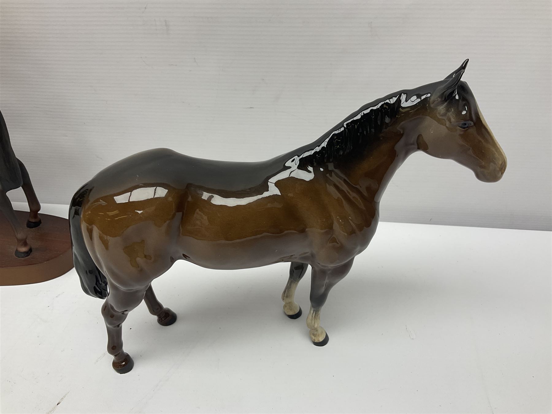 Four Beswick horse figures, comprising Quarter Horse, two Shires no 818 and matt palomino, together with Beswick donkey and Royal Doulton horse on a wooden plinth  
