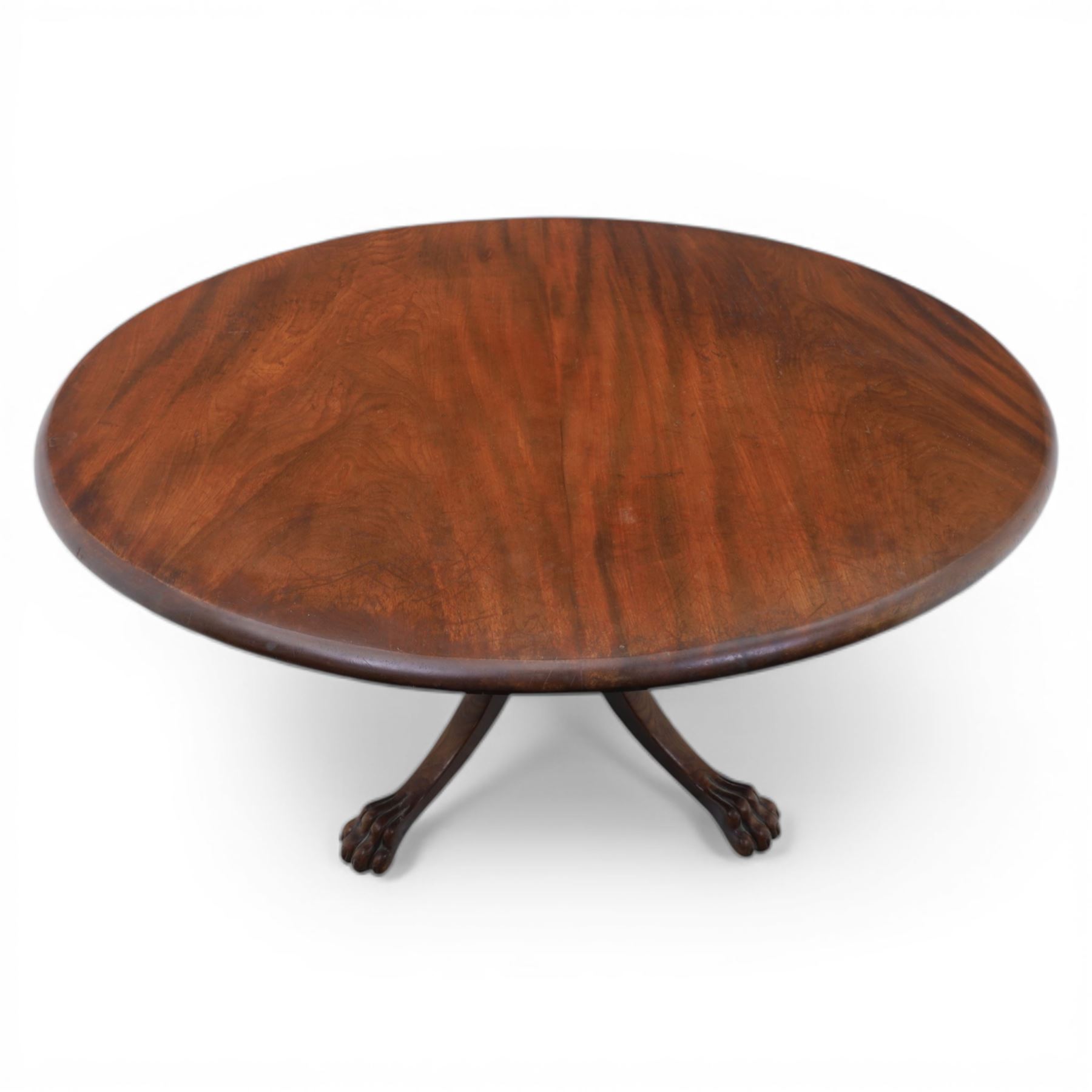 Victorian mahogany dining suite, oval tilt top dining table raised on a quatriform base with paw feet, together with a set of six balloon back dining chairs with green upholstery with cabriole legs 