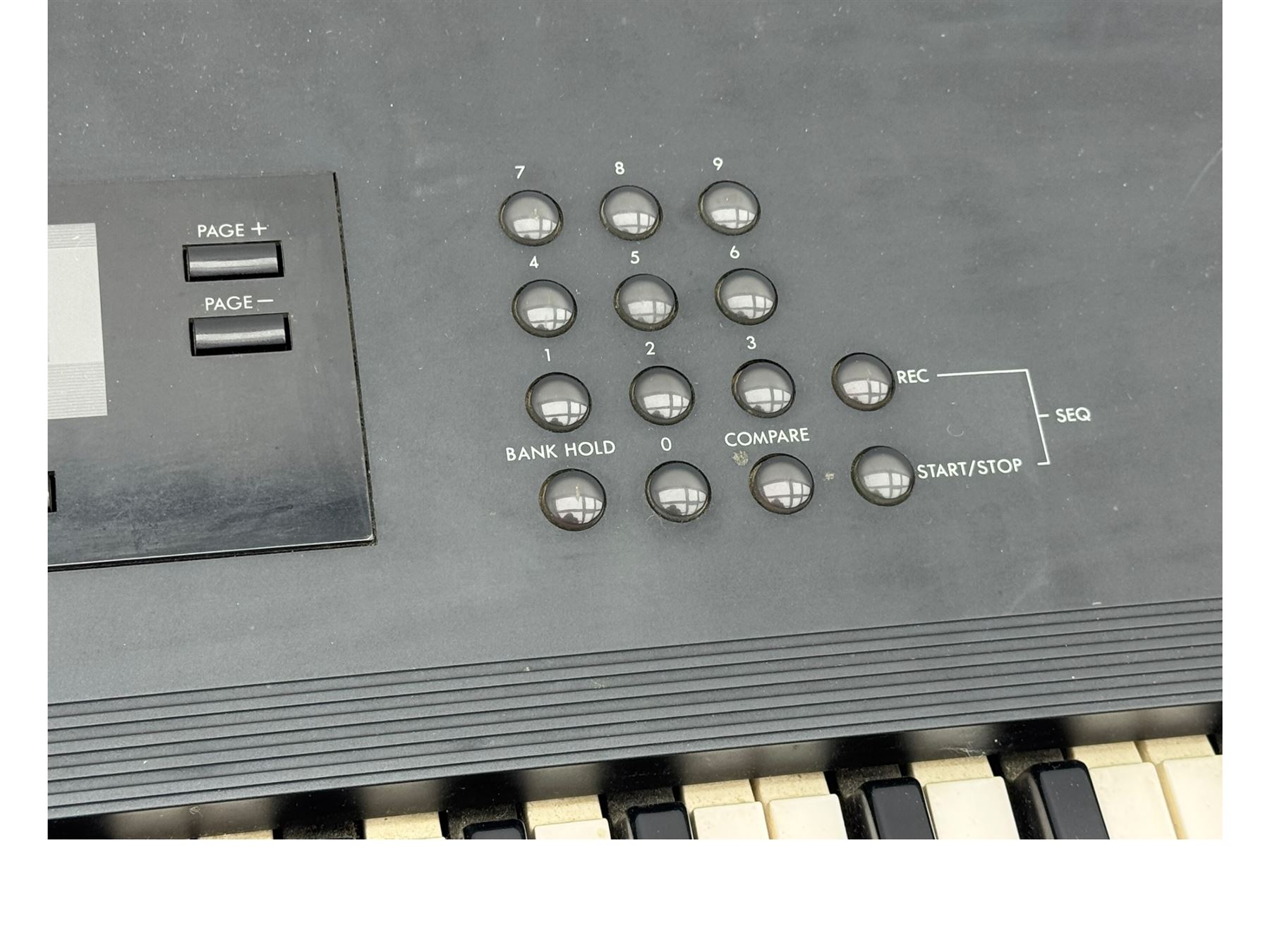 Korg M1 keyboard synthesiser, 61 velocity-sensitive keys with integrated multi-effects and eight-track sequencer, mounted on an adjustable black tubular X-frame stand with rubber end caps