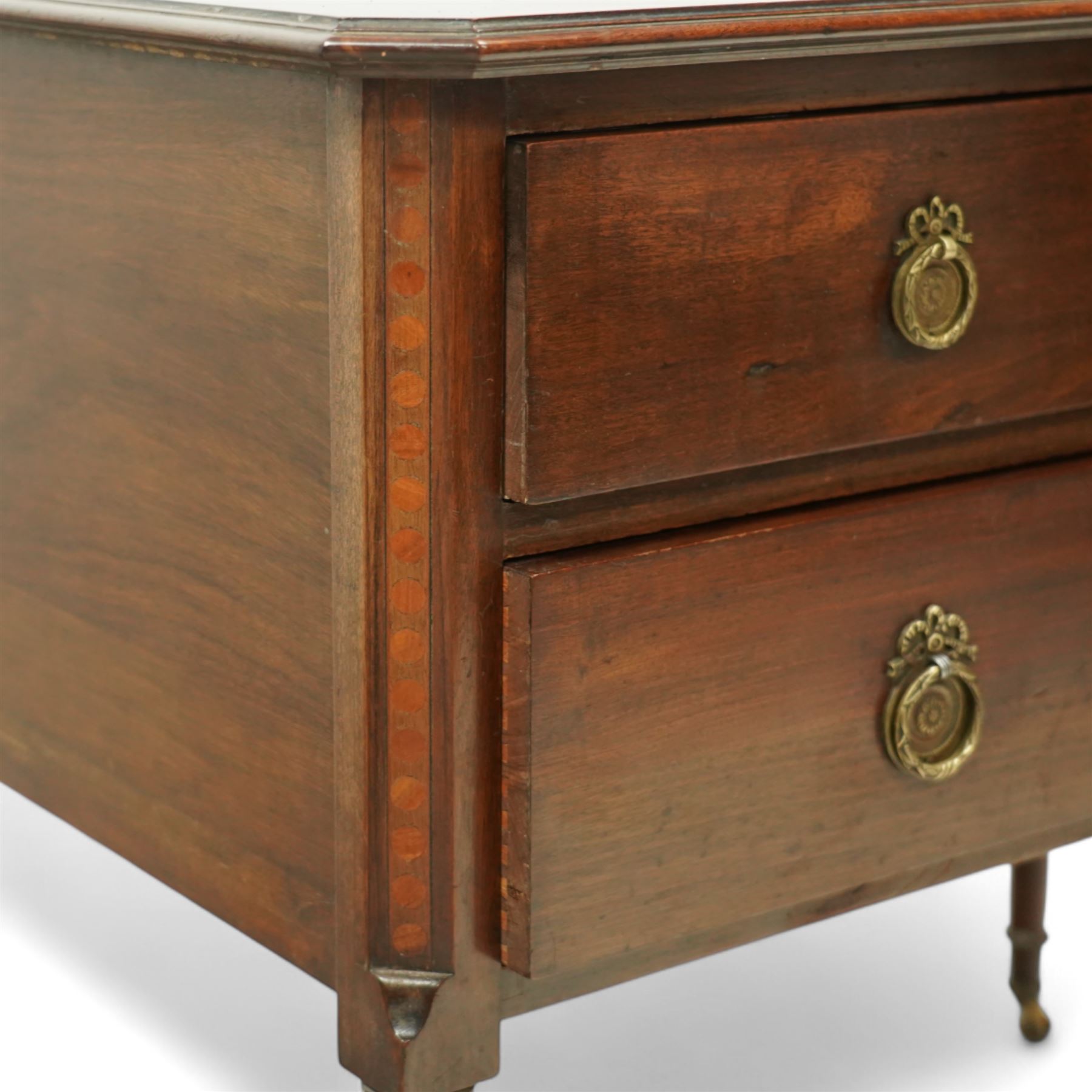 Early 20th century Regency-inspired mahogany two-drawer chest, rectangular top with moulded edge and shaped corners, above two full-width graduated drawers with ring handles, supported on turned tapered legs with brass castors                                                                                                                                                      
