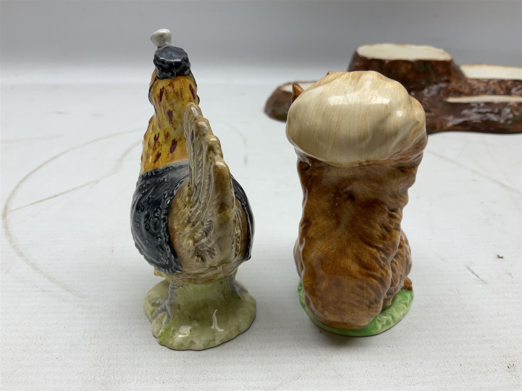 Seven Beswick Beatrix Potter figures, comprising Sally Henny Penny, Johnny Town-Mouse, Mrs Tiggy-Winkle, Mrs Tittlemouse, Tom Kitten, Pig-Wig and Squirrel Nutkin, together with a Beswick tree trunk display stand, stand L30cm