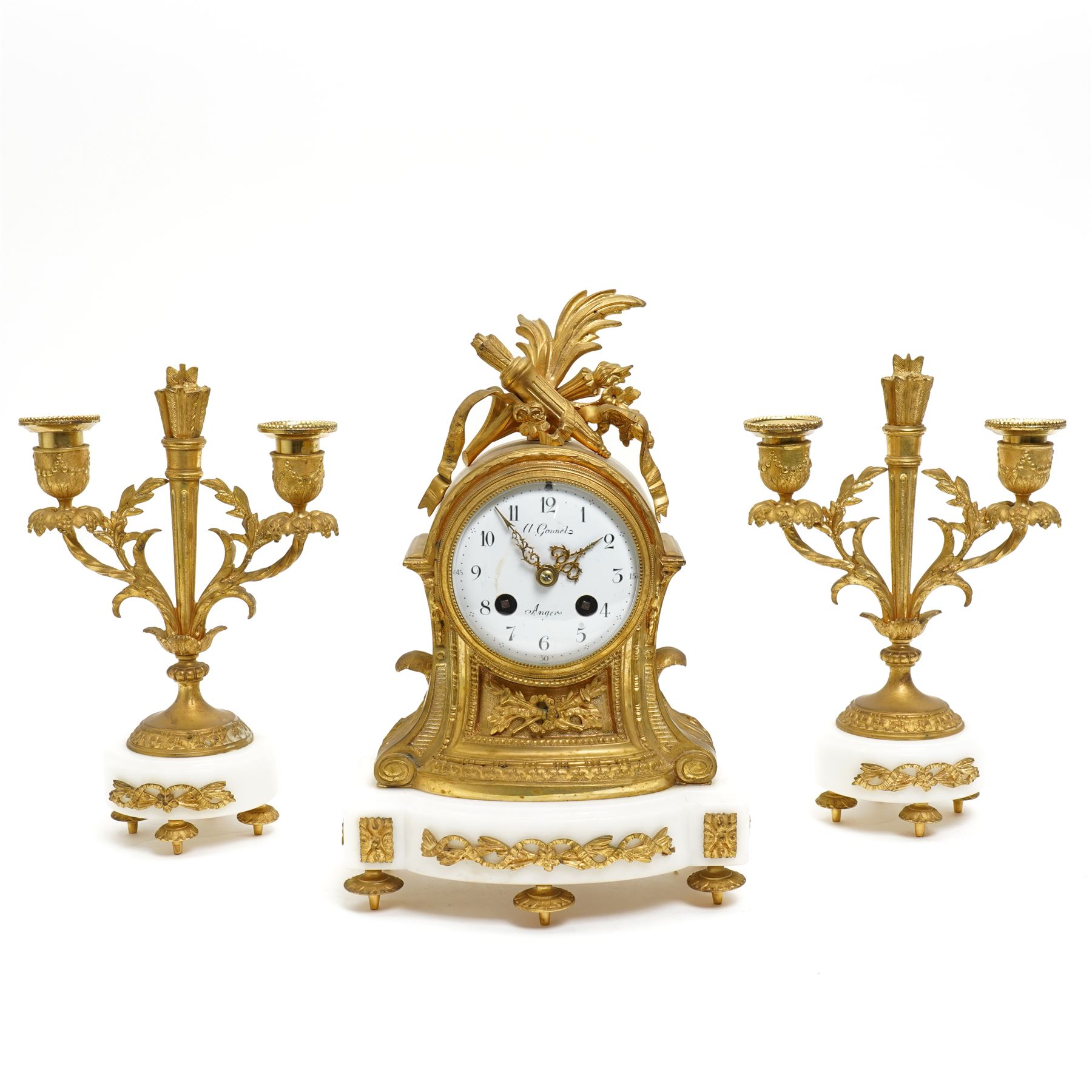 French-Ormolu and white marble mantle clock with garnitures, c 1910, with a white enamel dial and Arabic numerals, indistinct signature, pierced gilt-metal hands and minute markers, 8-day twin train countwheel striking movement, sounding the hours and half-hours on a bell, with a matching pair of two light candelabra. With pendulum and key.