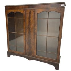 Early 20th century mahogany bookcase, foliate carved edge over banded frieze, fitted with two astragal glazed doors, on bracket feet