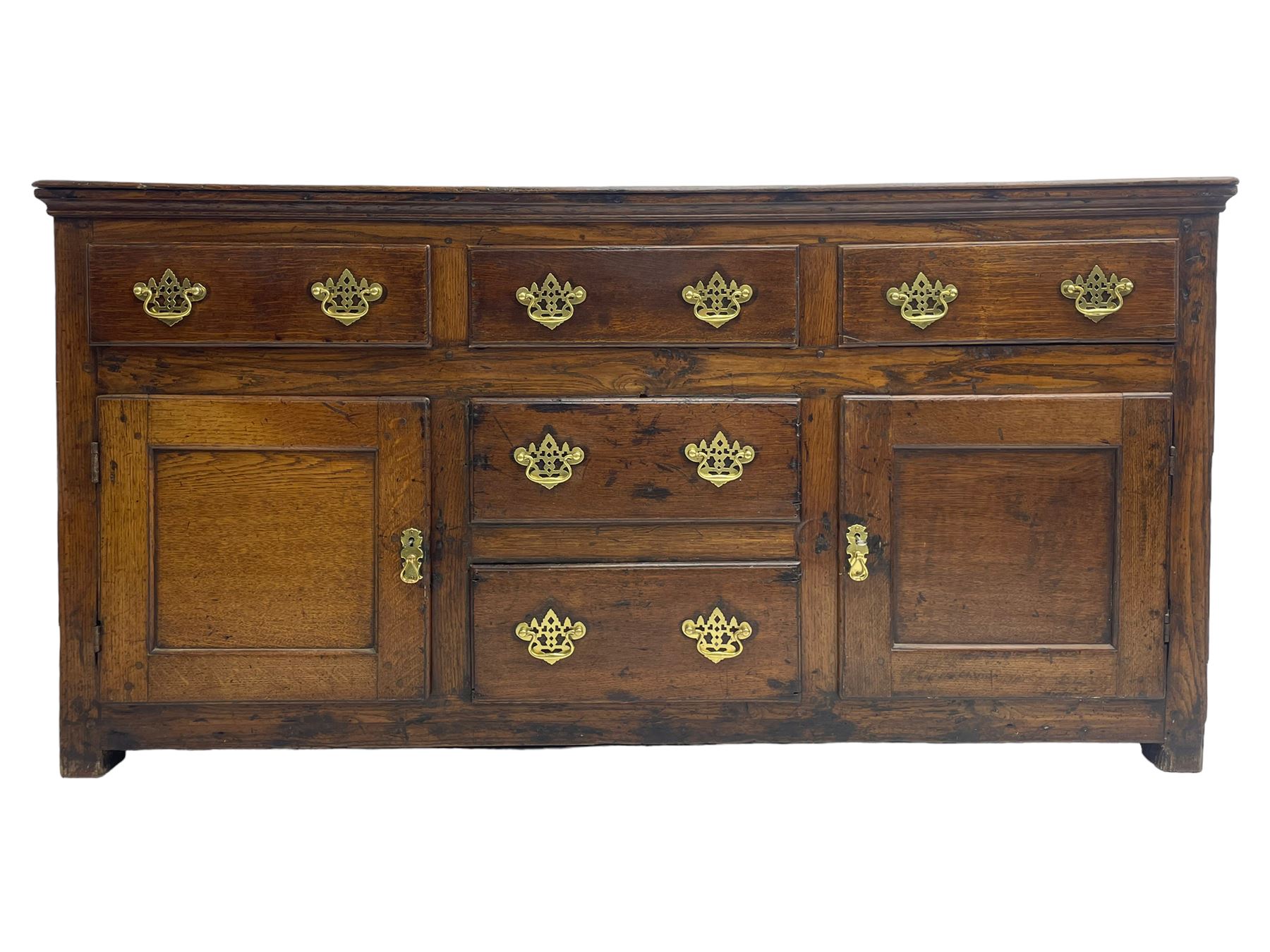 George III country oak dresser base,  rectangular top over with three central drawers flanked by two drawers and two panelled cupboards, each with moulded fronts, on stile feet