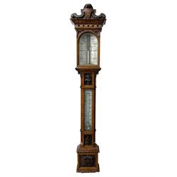 J Hicks - Hatton Garden London, - late 19th century carved oak cased Fitzroy barometer in a richly carved case with a carved crested pediment and square cistern cover, inverted opaline register reflecting FitzRoy's predictions and a scale from 27 to 31 inches of barometric pressure, with a thick bore cistern tube and adjustable rack and pinion twin vernier, fitted with a glazed snail bulb mercury thermometer recording the air temperature in both Fahrenheit and Celsius. Mercury clean and present.
James Joseph Hicks was born in Ireland, however, early in his life he moved to London where he was apprenticed to the instrument maker Louis P Casella. In 1860 he went into business in his own right as a scientific instrument maker at 8 Hatton Gardens. In 1864 he was granted membership to the British Meteorological Society and exhibited instruments at the Royal Society Exhibitions between 1876 and 1913. Hicks was one of London's most prolific and eminent barometer makers. 