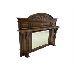 Oak overmantle mirror, arched pediment carved with shield and flanking fish with trailing scrollwork, panelled frieze over extending canopy raised by turned and fluted column pilasters, bevelled mirror plate 
