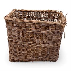 Large 20th century wicker laundry basket, of rectangular form, with stencilled lettering to one sides, raised on wooden base skids