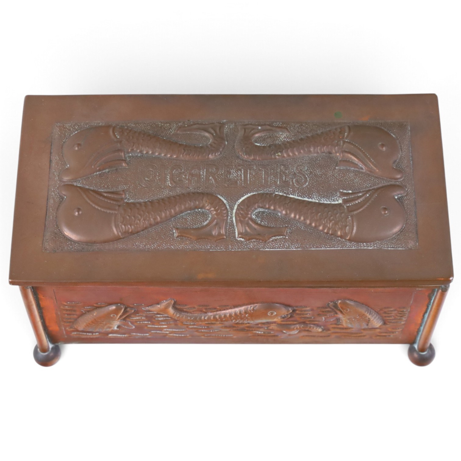 Art and Crafts copper and brass hammered casket, of rectangular form with repoussé decoration of dolphins, in the manner of  John Pearson, H10cm L19cm