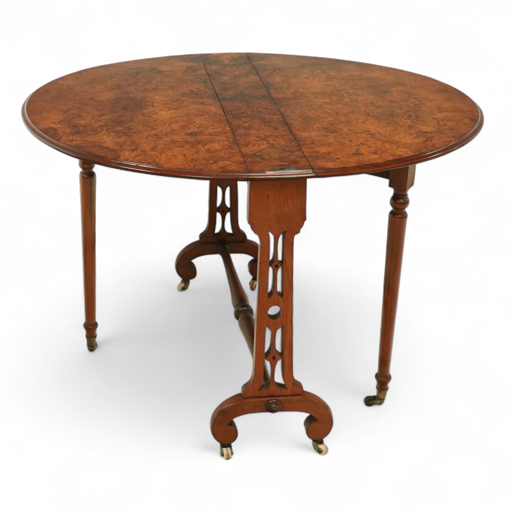 John Taylor & Son, Edinburgh - Late Victorian Aesthetic style walnut Sutherland table, with a hinged oval top on fret carved support, stamped John Taylor & Son Edinburgh, supported by scrolled feet on ceramic castor (Extended 105cm)