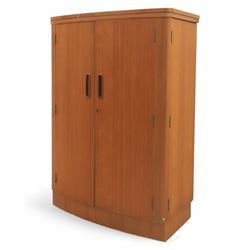 Turnbridge of London - Mid 20th century teak cocktail cabinet, with fold out top extending to 160cm, with twin doors revealing a shelved interior, the back with sliding glazed doors, raised on a recessed plinth base with castors