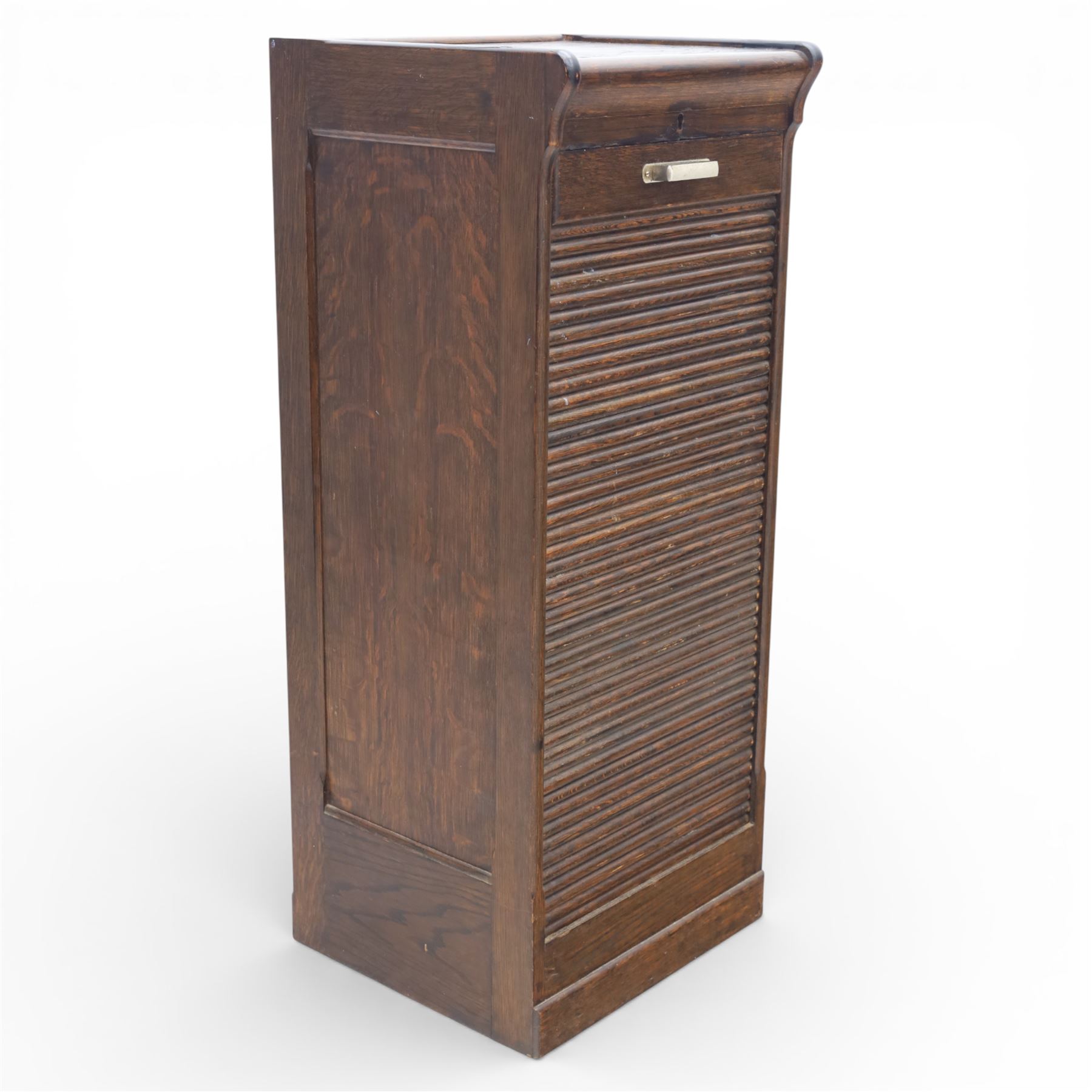 Early 20th century oak tambour front fitted cabinet, rectangular top with rounded corners over a roll tambour front enclosing a fitted interior of multiple shallow drawers with cut-out pulls, the sides with rounded uprights, on a stepped plinth base