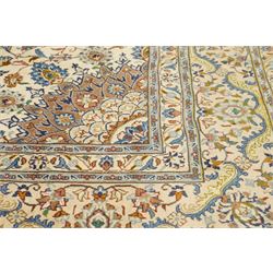 Central Persian Nain hand-knotted carpet, ivory field with central radiating medallion with pendants, issuing an all-over design of scrolling vines, palmettes, and floral sprays within confirming spandrels, framed a complimentary foliate border flanked by multiple guard stripes, with cotton fringe ends 