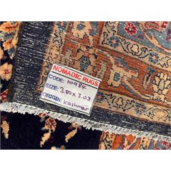 Northeastern Persian Meshed carpet, the deep navy field with a symmetrical floral arrangement of stylised flowerheads, palmettes and scrolling vines issuing from a central urn, enclosed by broad rust and blue borders of floral arabesques and lotus forms, from the region of Meshed