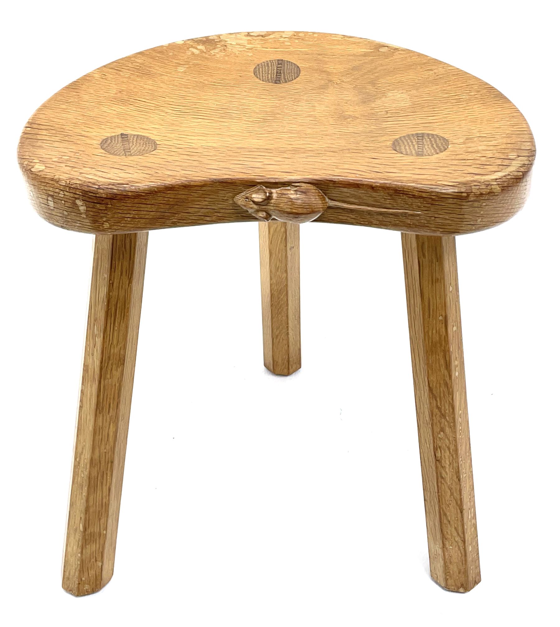 'Mouseman' oak three legged stool with dished kidney shaped seat, tapered octagonal supports, with carved mouse signature, by Robert Thompson of Kilburn 