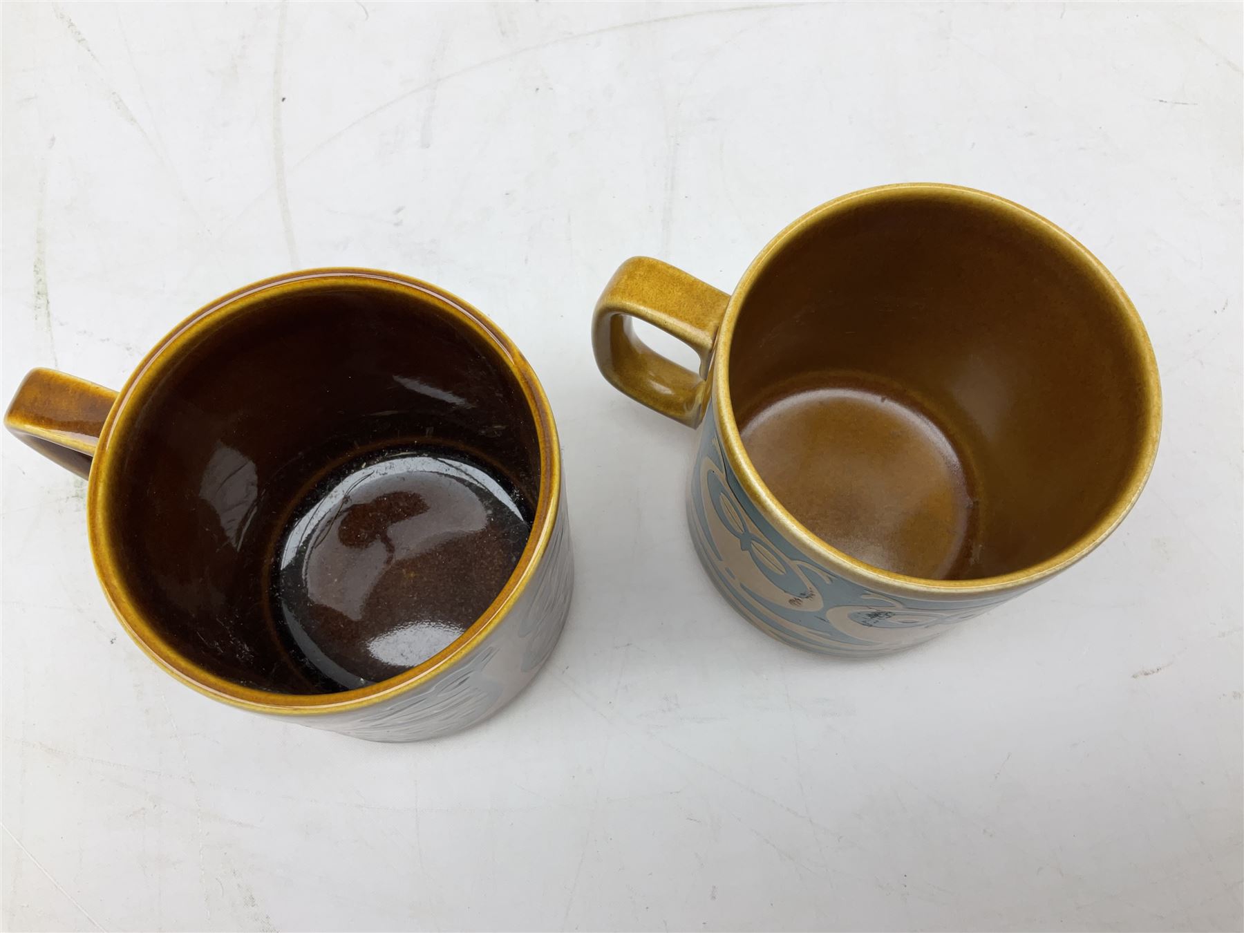 Collection of 1970s Hornsea mugs designed by John Clappison, comprising six Train Robber pattern examples together with owl patterned example on dark teal ground, and further example decorated with stylised hen and chick and egg, approx 9cm, together with four small cup bowls, all with stamped Hornsea marks beneath
