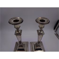 Pair of 1920s silver mounted candle sticks, each with part fluted candle holders and removable sconces, upon a tapering stem and weighted stepped square foot, with beaded rims, hallmarked James Ramsay, Sheffield 1922, H25.5cm 