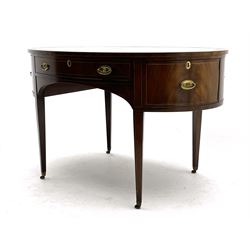Georgian style mahogany and yew wood banded oval library writing table, the top with tooled and gilt brown leather inset, fitted with drawer, two cupboards and shelf, raised on square tapering supports terminating at brass castors, boxwood stringing