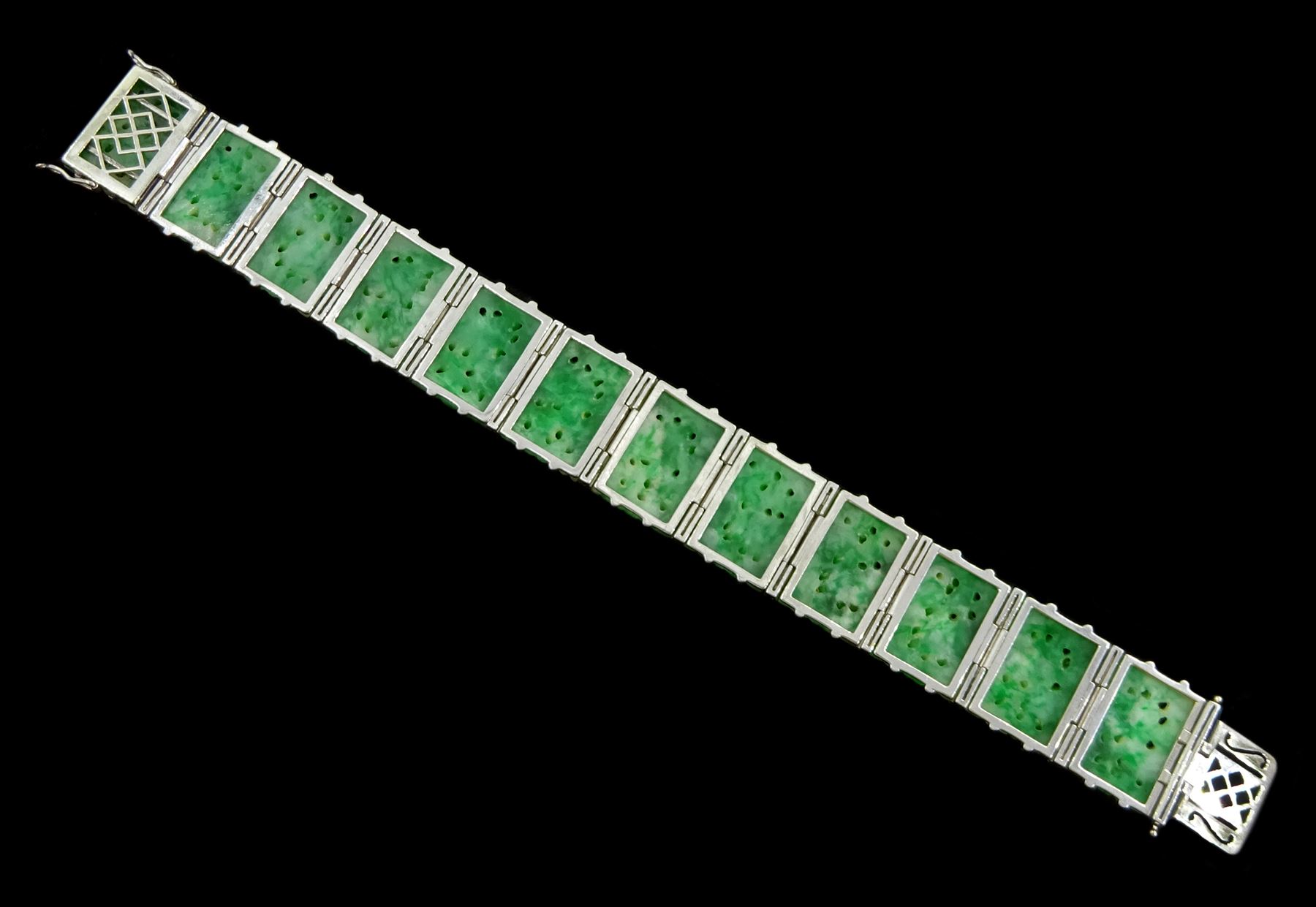 Art Deco platinum and white gold jadeite and diamond bracelet, twelve carved foliate jadeite panels, separated by a row of milgrain set old cut diamonds