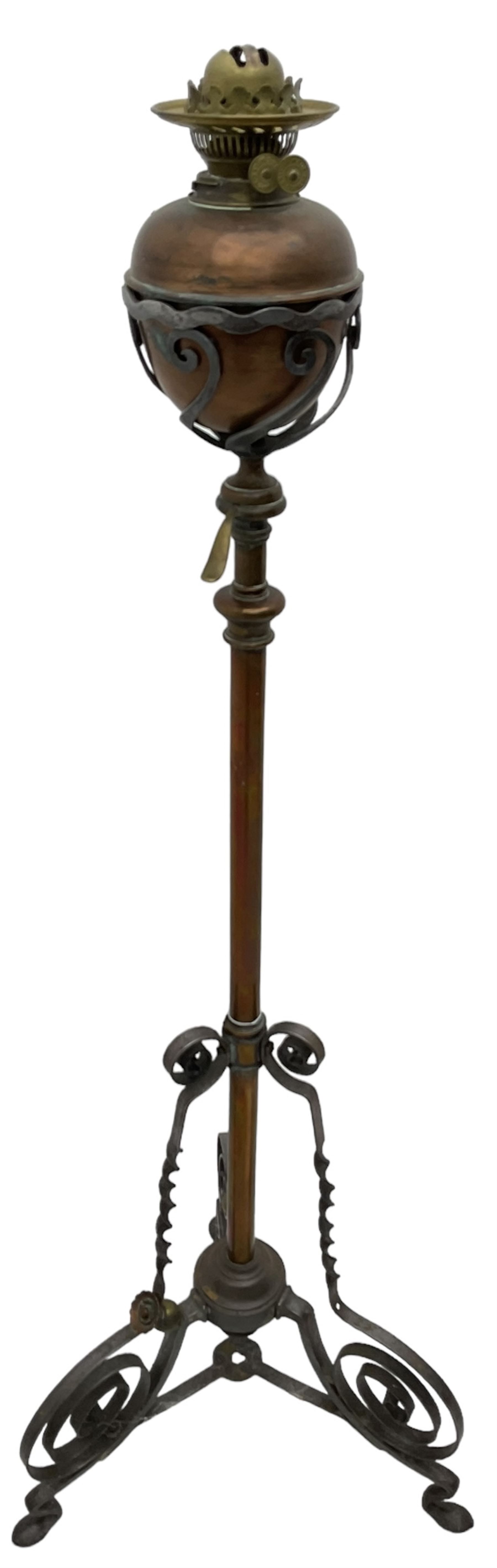 Late 19th to early 20th century wrought metal and copper telescopic oil standard lamp, the lamp and reservoir on scrolled supports with waved band, handle operating telescopic action, tripod base with scrolled terminals and twisted decoration, splayed pad feet 