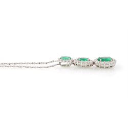 18ct white gold emerald and diamond cluster pendant, three graduating oval cut emeralds, each surrounded by round brilliant cut diamonds, Birmingham 2010, on a fine silver chain, total emerald weight approx 1.05 carat, total diamond weight approx 0.55 carat