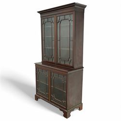 Early 20th century Chippendale design mahogany bookcase, projecting moulded cornice over four astragal glazed doors, the interior fitted with adjustable shelves, on bracket feet 