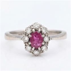 White gold ruby and diamond cluster ring, single oval cut ruby of approx 0.45 carat, surro...