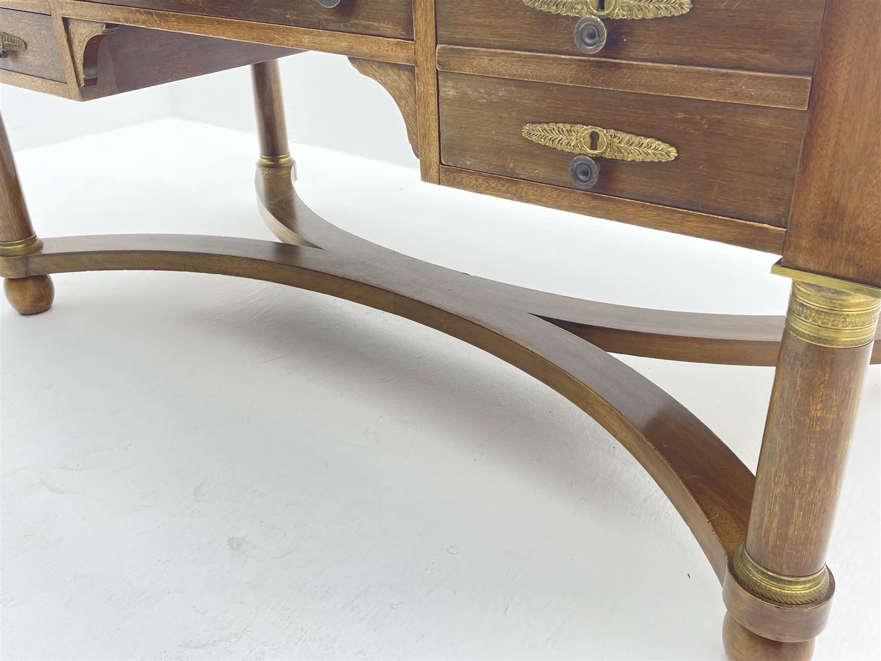 French Empire style walnut desk, moulded rectangular top with inset leather, two leather inset slides either side, fitted with four drawers, turned supports joined by curved x-shaped stretchers, gilt metal mounts 