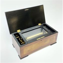 A bur walnut veneered musical box, or regular form with ebonised feet and sides of the hinged opening cover, opening to reveal an ebonised interior, 15cm long cylinder, and comb, box L34cm.