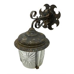 Wrought iron wall lantern with patterned glass shade of tapering cylindrical form, H29cm