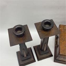Pair of Arts & Crafts style oak candlesticks, of tapering form with stepped square base, together with an oak box with twin handles and brass escutcheon, the inside with green paper label reading 'Gentlemen's Tool Chest' and an oak tobacco box in the form of a barrel with silver plated bun feet, by Teofani & Co London, candlesticks H26cm
