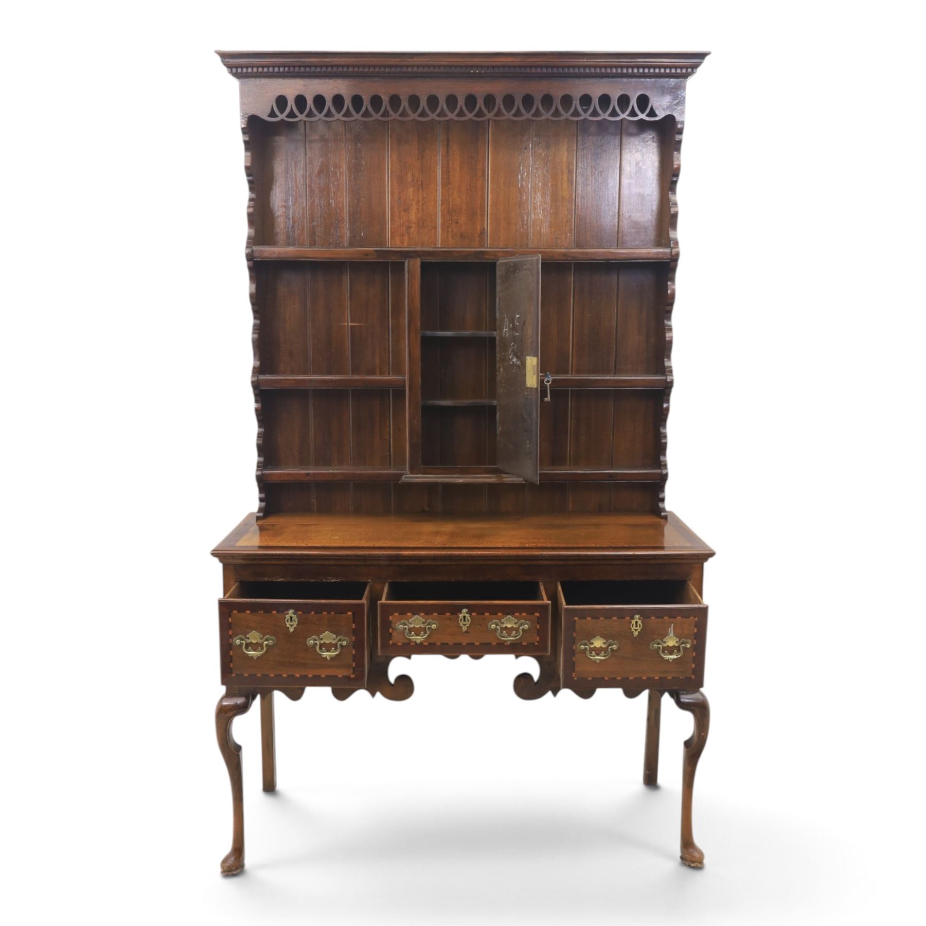Late 19th century inlaid oak dresser and plate rack, plate rack with projecting cornice and fretwork, with three shaped shelves for plates, central cupboard with inlaid shell and border, brass escutcheon and key, the lower section with crossabanded top, above three drawers with brass handles and inlaid border, shaped apron raised on cabriole supports 