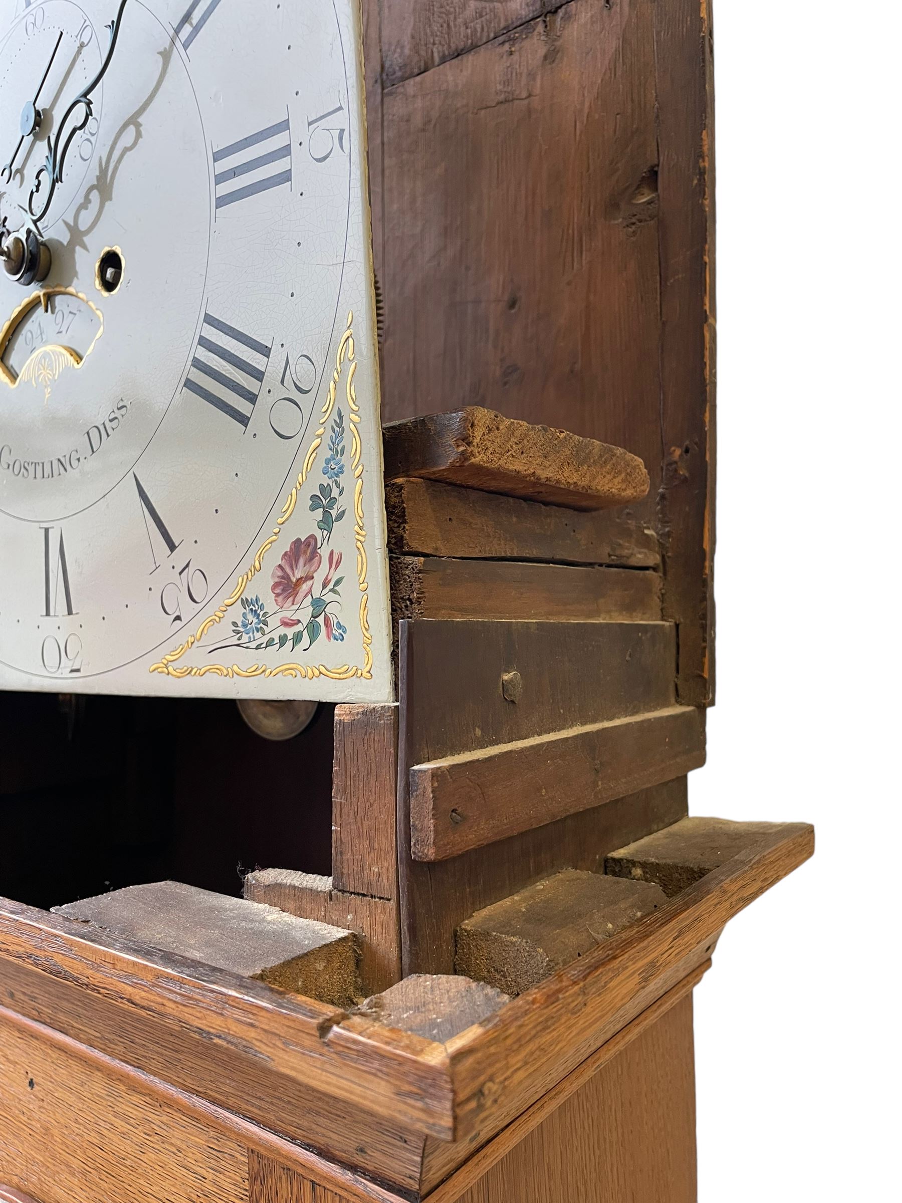 William Gostling of Diss  (Norfolk)-  Late 18th century 8-day oak longcase clock c1780-90, break arch top with scalloped cresting and three brass finials, glazed break arch hood door flanked by turned pilasters with brass capitals, trunk with a long trunk door and rounded top on a square plinth with an applied and shaped skirting, early painted Wilson of Birmingham dial with Roman numerals and five minute Arabic's, matching steel hands and second pointer, arched square ended calendar aperture with date disc behind, floral spandrels within gesso borders and a painted rocking automaton representing Mercury to the break arch, dial pinned via a false plate to a weight driven rack striking movement with a recoil anchor escapement, striking the hours on a cast bell. With pendulum weights and key. 
William Gostling (II) is recorded as working in Diss from 1774 to 1797, succeeded by widow Anne and son George . The dial of this clock is illustrated and discussed in detail in M.F. Tennants book 