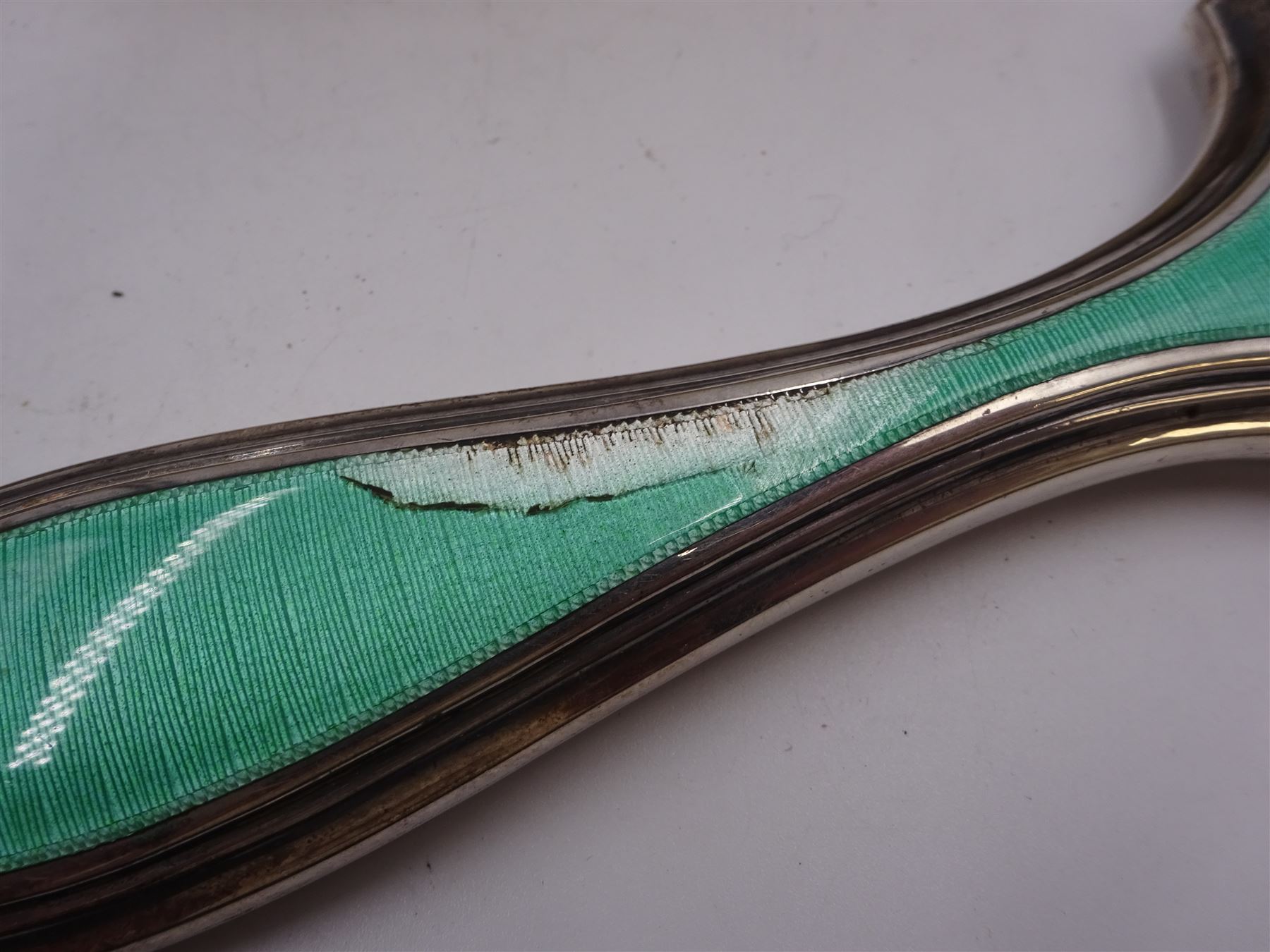 Art Deco five piece green guilloche enamel silver dressing table set, comprising hand mirror, two hair brushes and two clothes brushes hallmarked Barker Brothers Silver Ltd, Birmingham 1930, together with another silver brush, hallmarked Davis, Moss & Co, Birmingham 1928 (6)