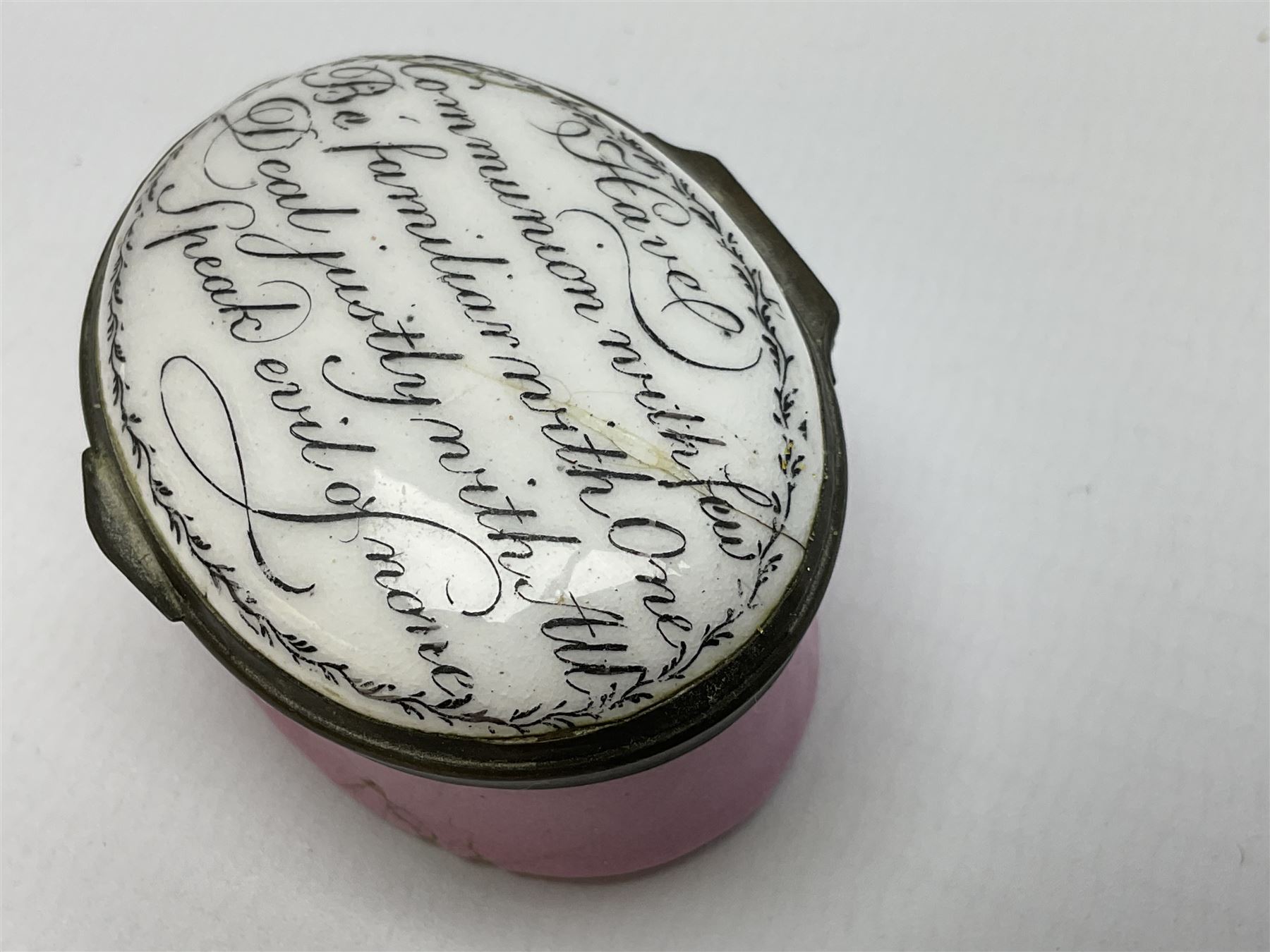 Late 18th century Staffordshire enamel patch box, of oval form with pink base, the hinged cover inscribed 'Have Communion with few, Be familiar with One, Deal justly with All, Speak evil of none' upon a white ground, opening to reveal mirror beneath, W4cm