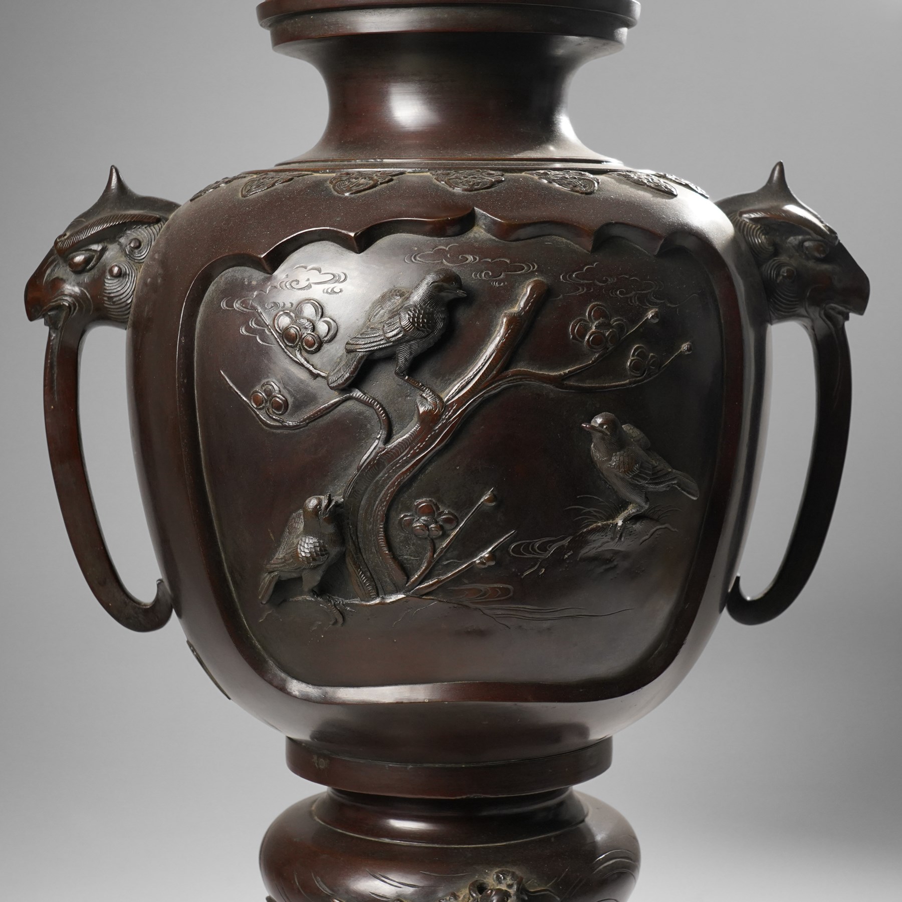 Japanese late Meiji period bronze koro and cover, surmounted by an eagle finial and with bird decoration in high relief to each side, twin elephant trunk handles, bearing indistinct character signature to one side, H82cm