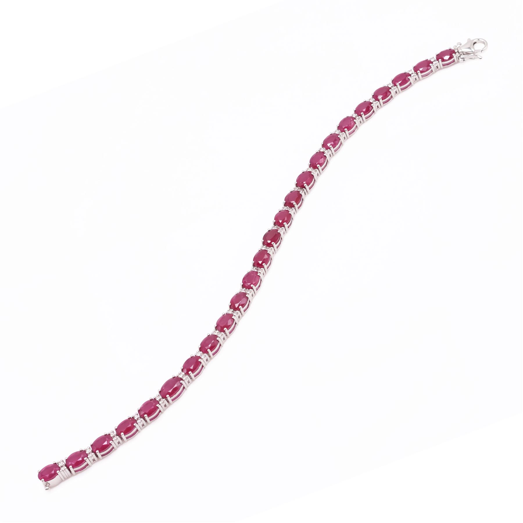 18ct white gold ruby and diamond bracelet, twenty-six oval cut rubies, each spaced by two round brilliant cut diamonds, stamped 750, total ruby weight 12.70 carat, total diamond weight 0.46 carat
