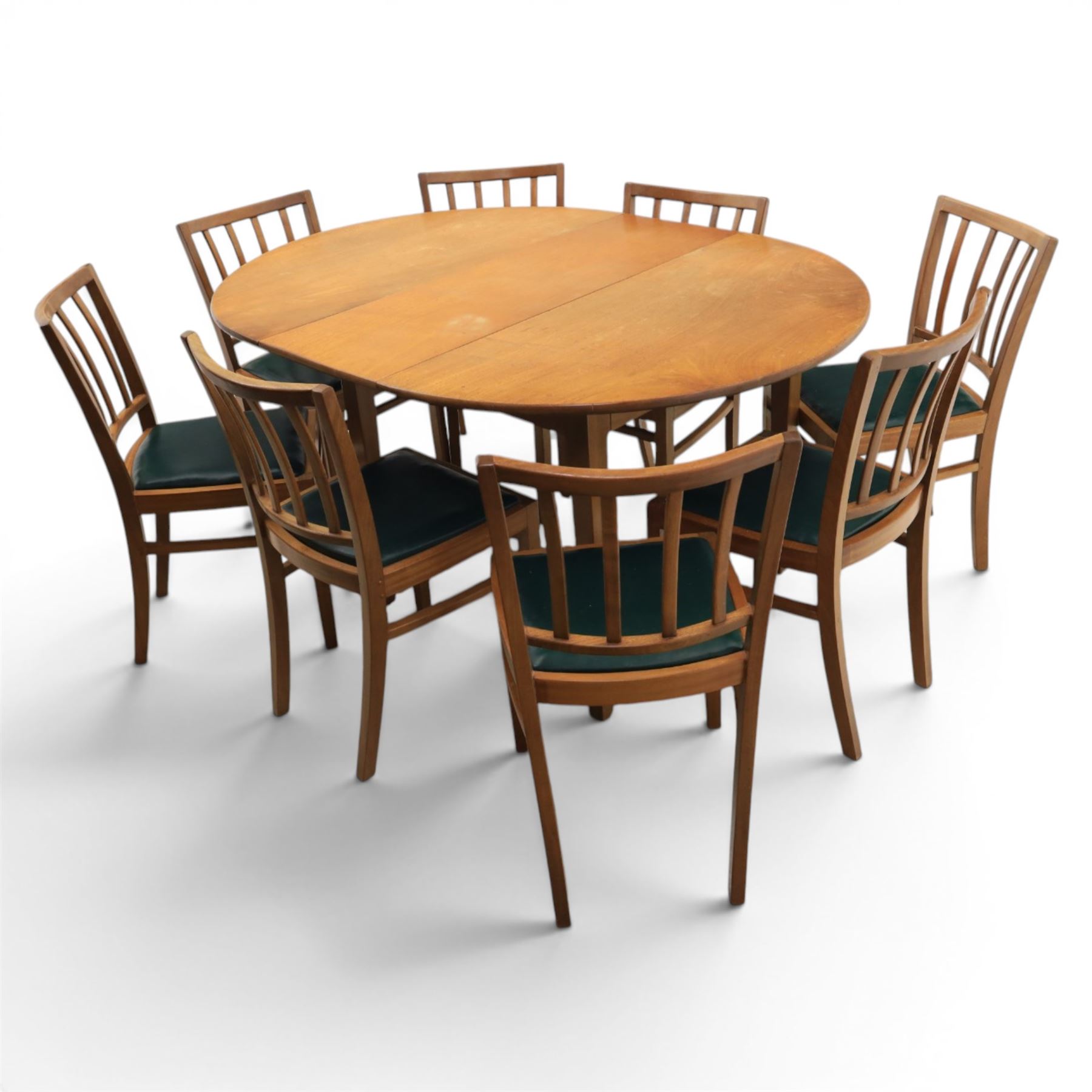 Mid 20th century teak extending dining table, together with eight teak chairs with green leather seats, extends to 154cm