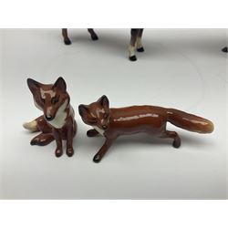 Beswick hunting group, comprising huntswoman on dappled grey horse no 1730, huntsman on bay horse no 1501, two fox figures no 1440 and 1748, and four fox hounds, all with printed marks beneath (8)