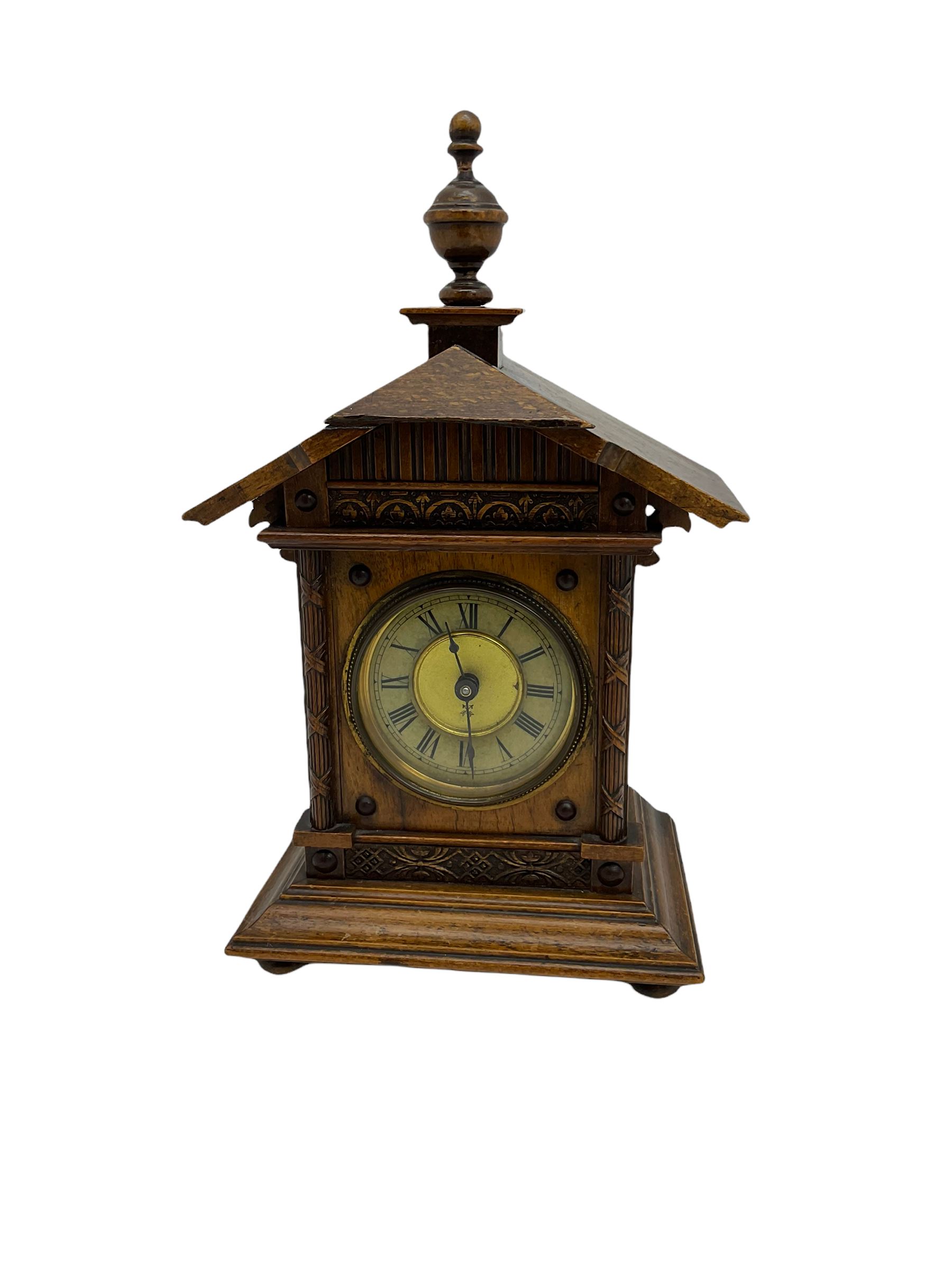A German musical alarm clock (model 1523/24) made by the Hamburg Amerikanische Uhrenfabrik c1880, in an oak case with an architectural top and finial, two-part dial with a gilt centre, ivorine chapter and steel spade hands, with roman numerals and minute track, case raised on four bun feet, with a thirty-hour balance wheel pin pallet spring driven movement sounding the alarm on a musical movement, key wound and set from the rear. Compete with three different and changeable musical movements in their original box. These clocks would have been sold as here with separate musical movements, it is rare to find them with the original clock.
H30 W17 D11 

	




