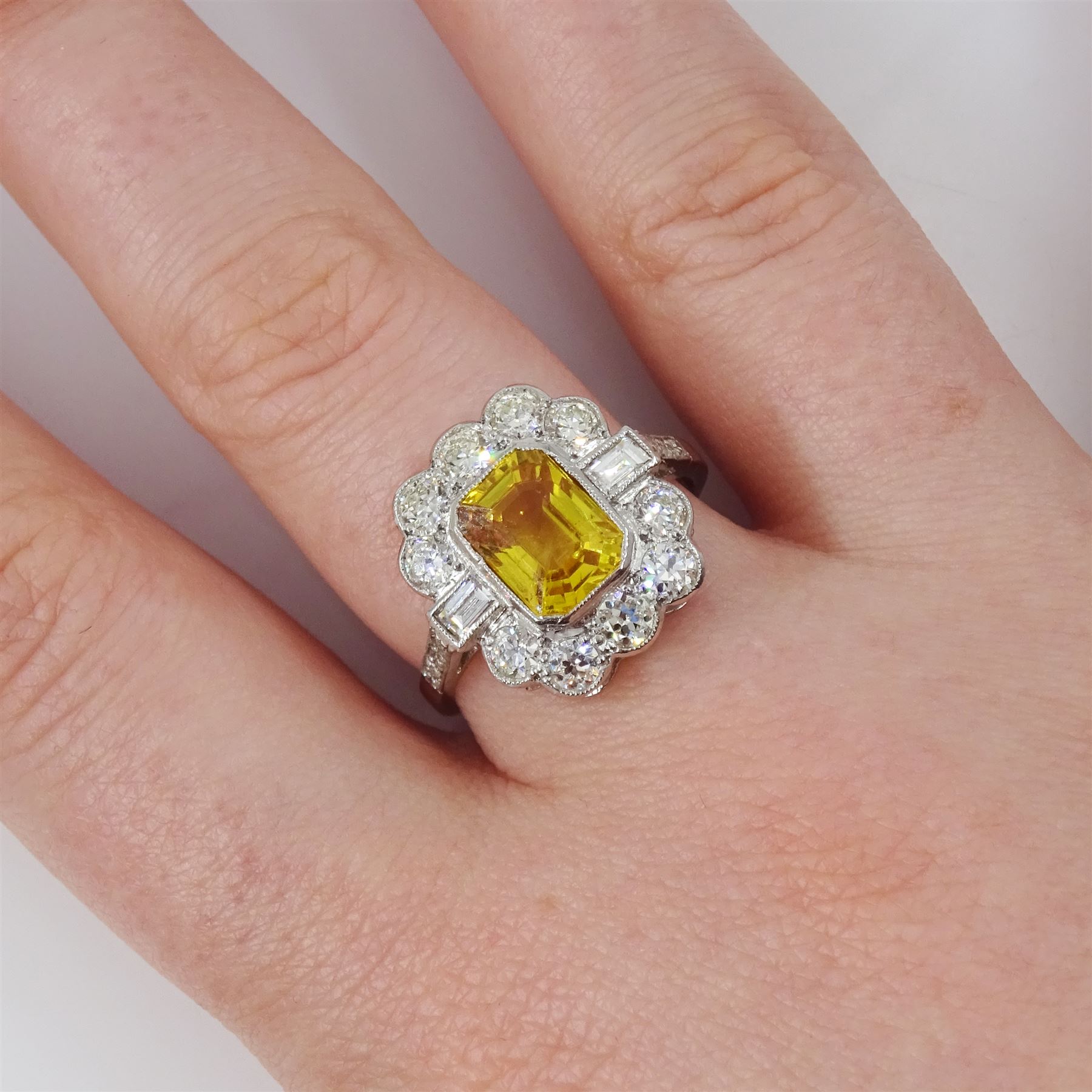 Platinum yellow sapphire and diamond milgrain set cluster ring, single octagonal cut sapphire of approx 2.20 carat, surrounded by two baguette cut diamonds and ten transitional cut diamonds and diamond set shoulders, stamped Plat, total diamond weight approx 0.95 carat