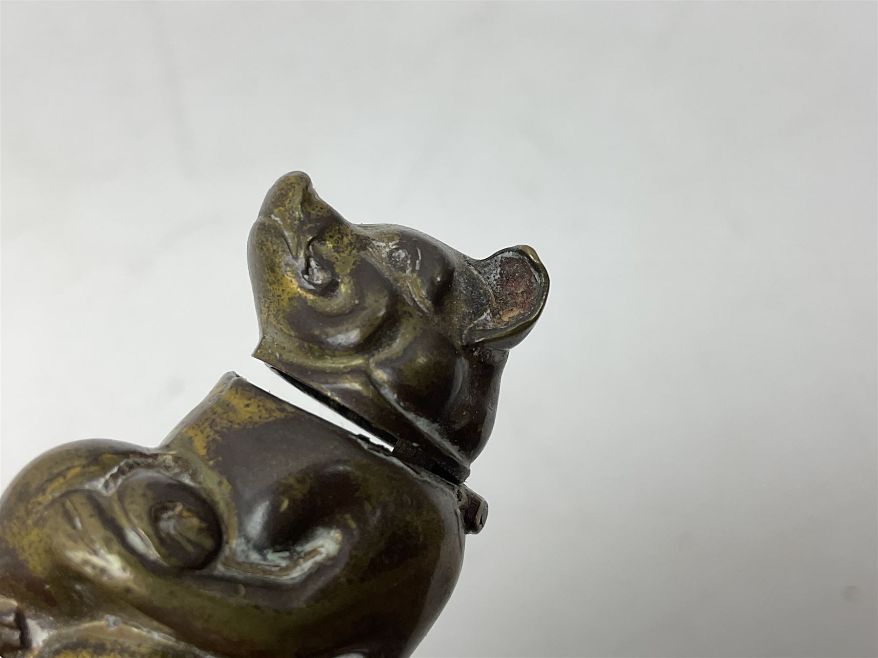 Victorian novelty brass vesta case modelled in the form of a pig holding a money bag, together with a silver vesta, hallmarked 
