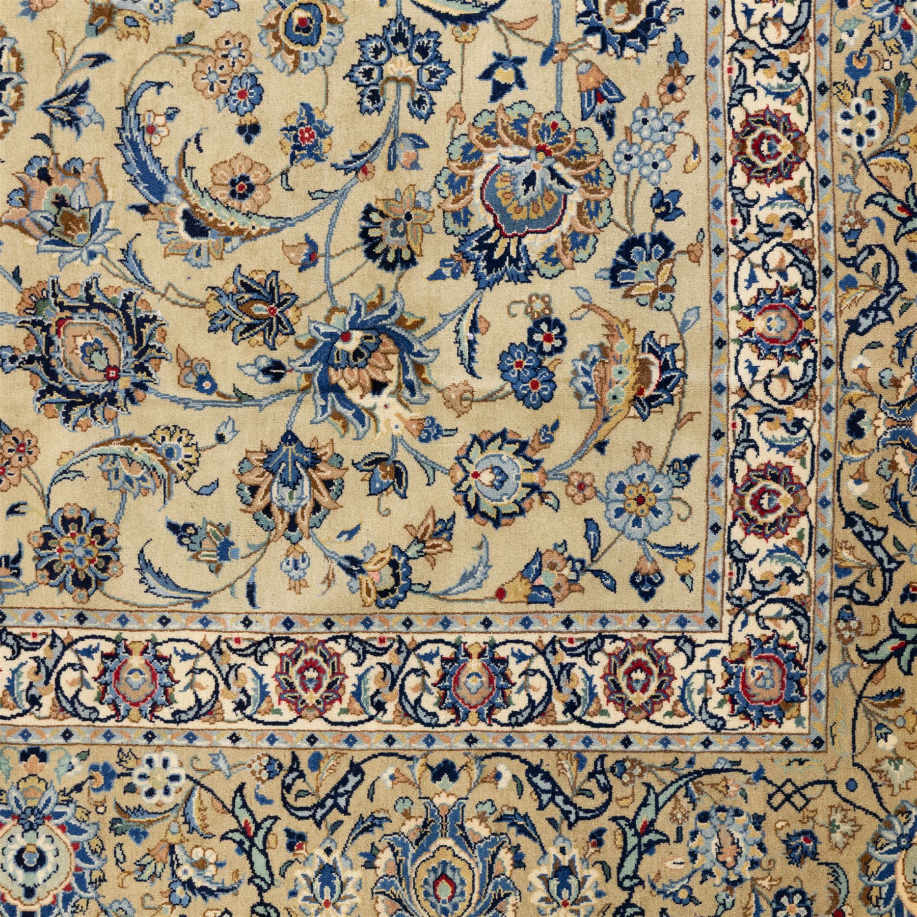 Persian Kashan carpet, beige ground, field with an all-over design of scrolling palmettes and floral sprays in blue and terracotta within a ivory ground and pale blue floral border