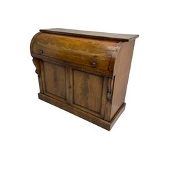 Victorian mahogany roll-top writing desk, top concealing fitted interior with pigeonholes and three drawers, the trisector inset writing surface with writing slope, base fitted with panelled cupboard enclosing single shelf, decorated with scrolled corbels