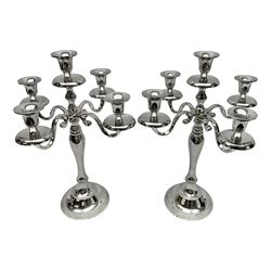 Pair of four branch candelabras, urn-shaped nozzles raised upon scroll branches supported from tapering central stem, with a stepped circular base, H40cm