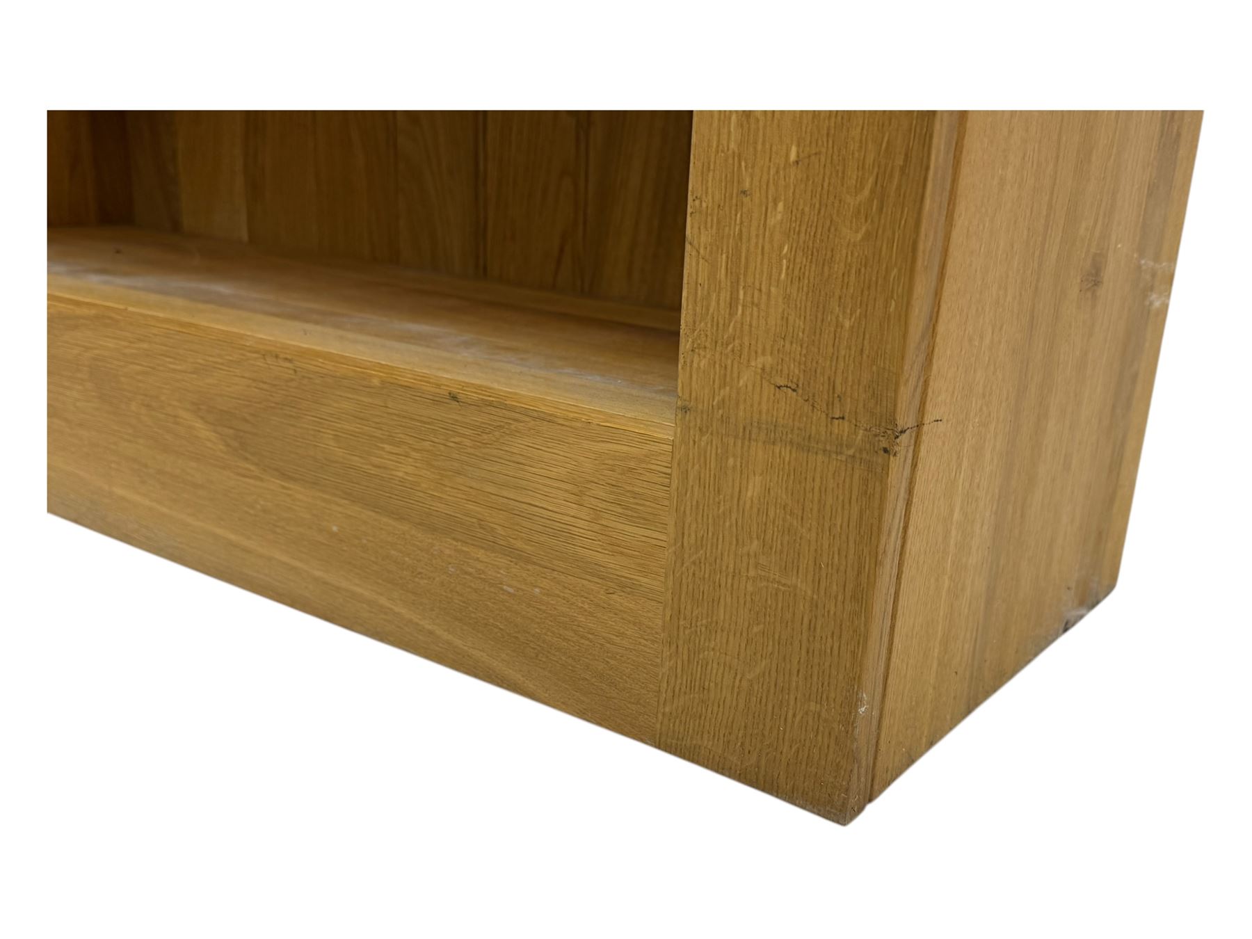 Contemporary light oak open bookcase, rectangular form with projecting top, fitted with five adjustable shelves, on a straight plinth base